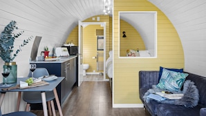 A compact living space with a kitchen, dining area, and a cozy seating area. - Morgan Sweet Glamping Pod - Free Wi-Fi (Wells)