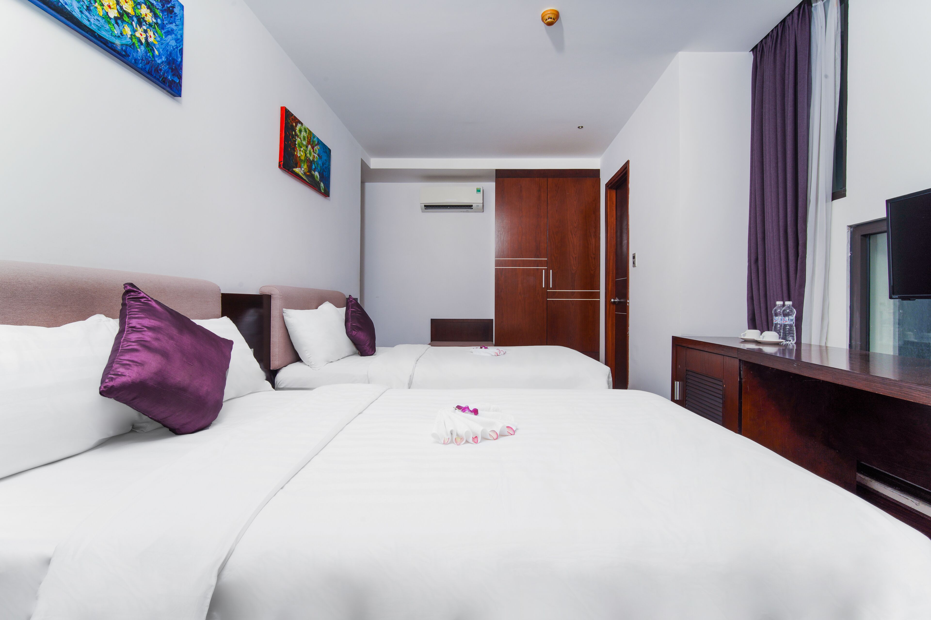 Une chambre d’hôtel avec deux lits, une télévision, un bureau et un appareil de climatisation.