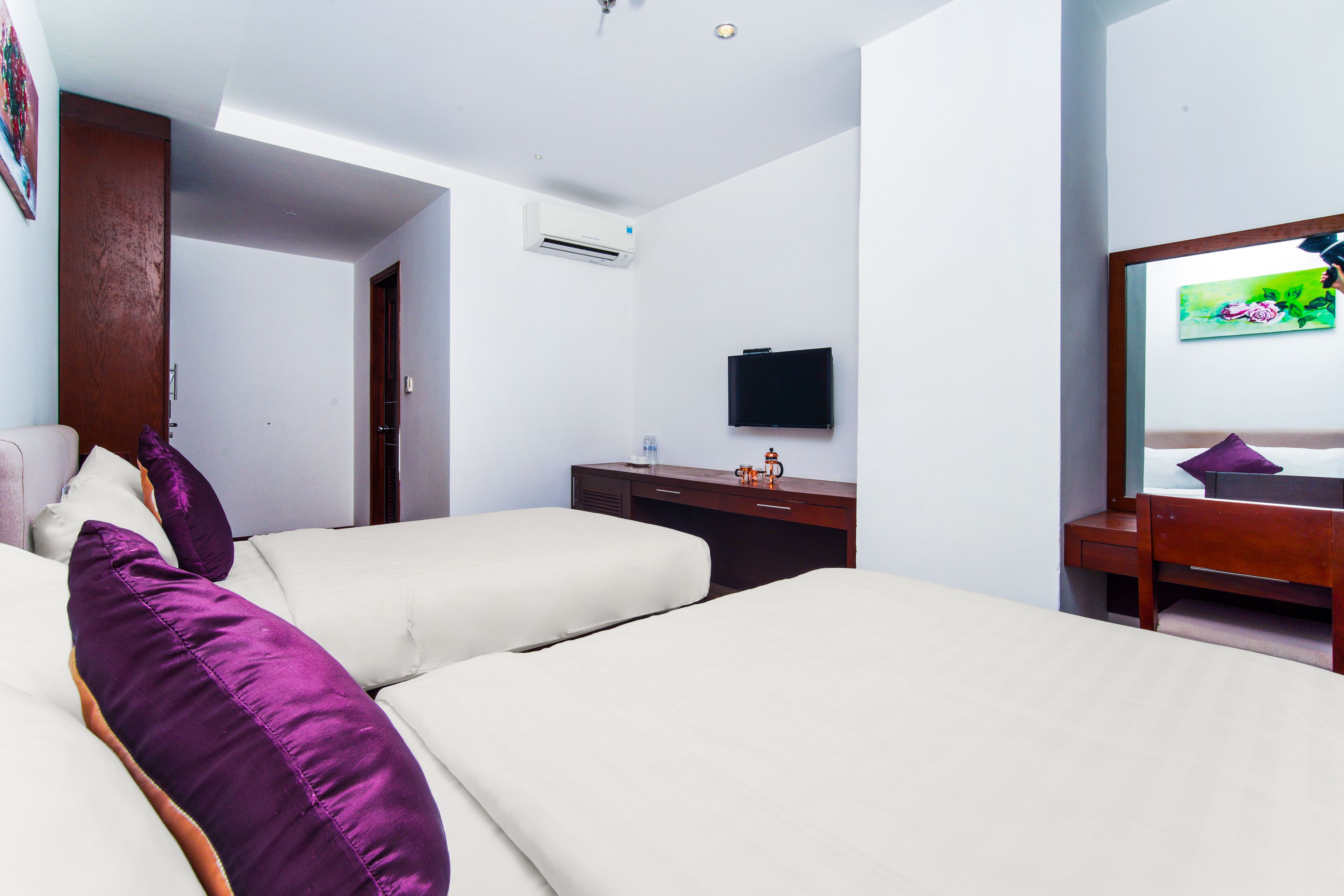 Une chambre d’hôtel avec deux lits, un bureau, une télévision et un appareil de climatisation.