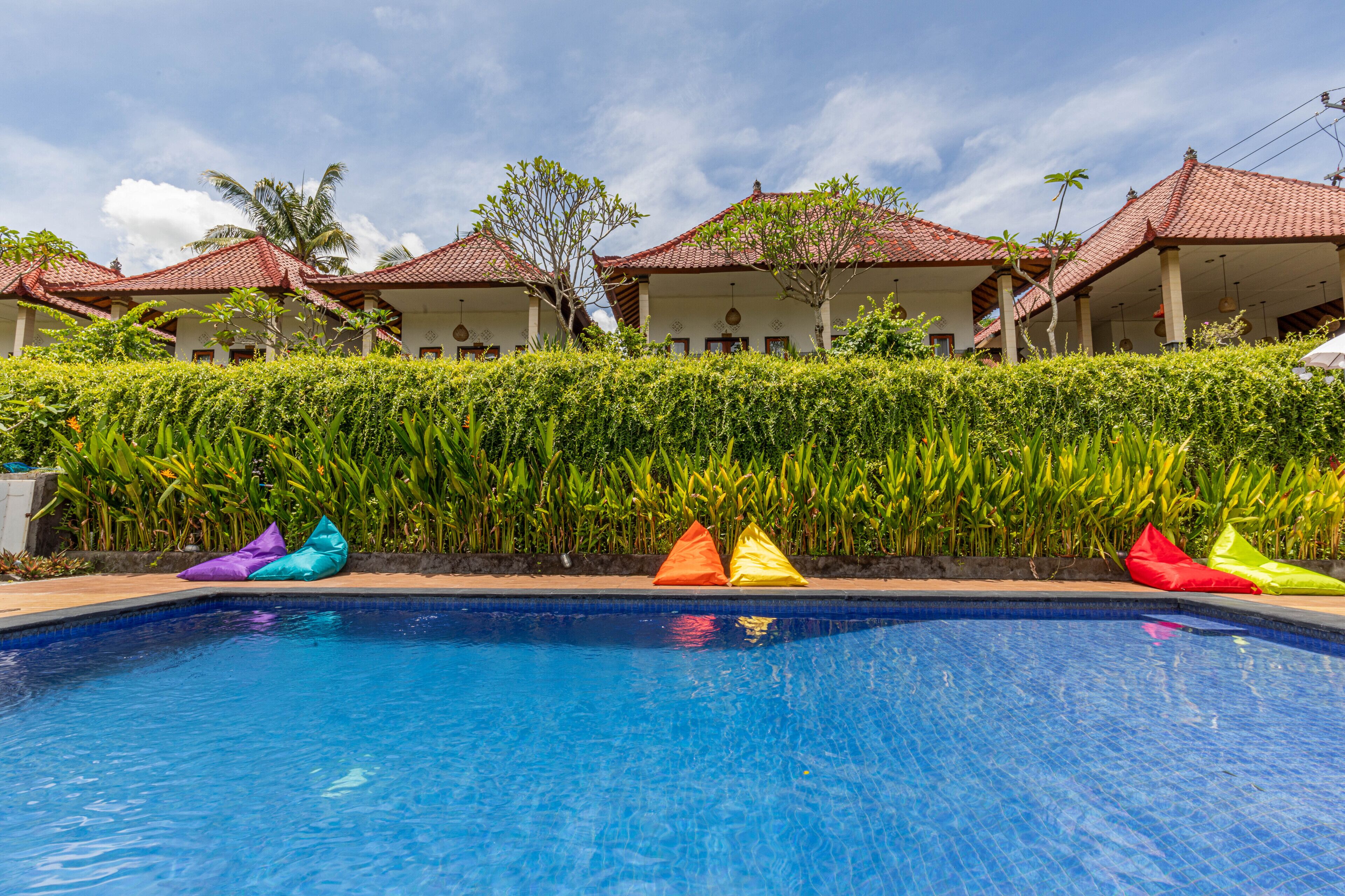 Piscina com bean bags coloridos e uma fileira de edifícios com telhados vermelhos.