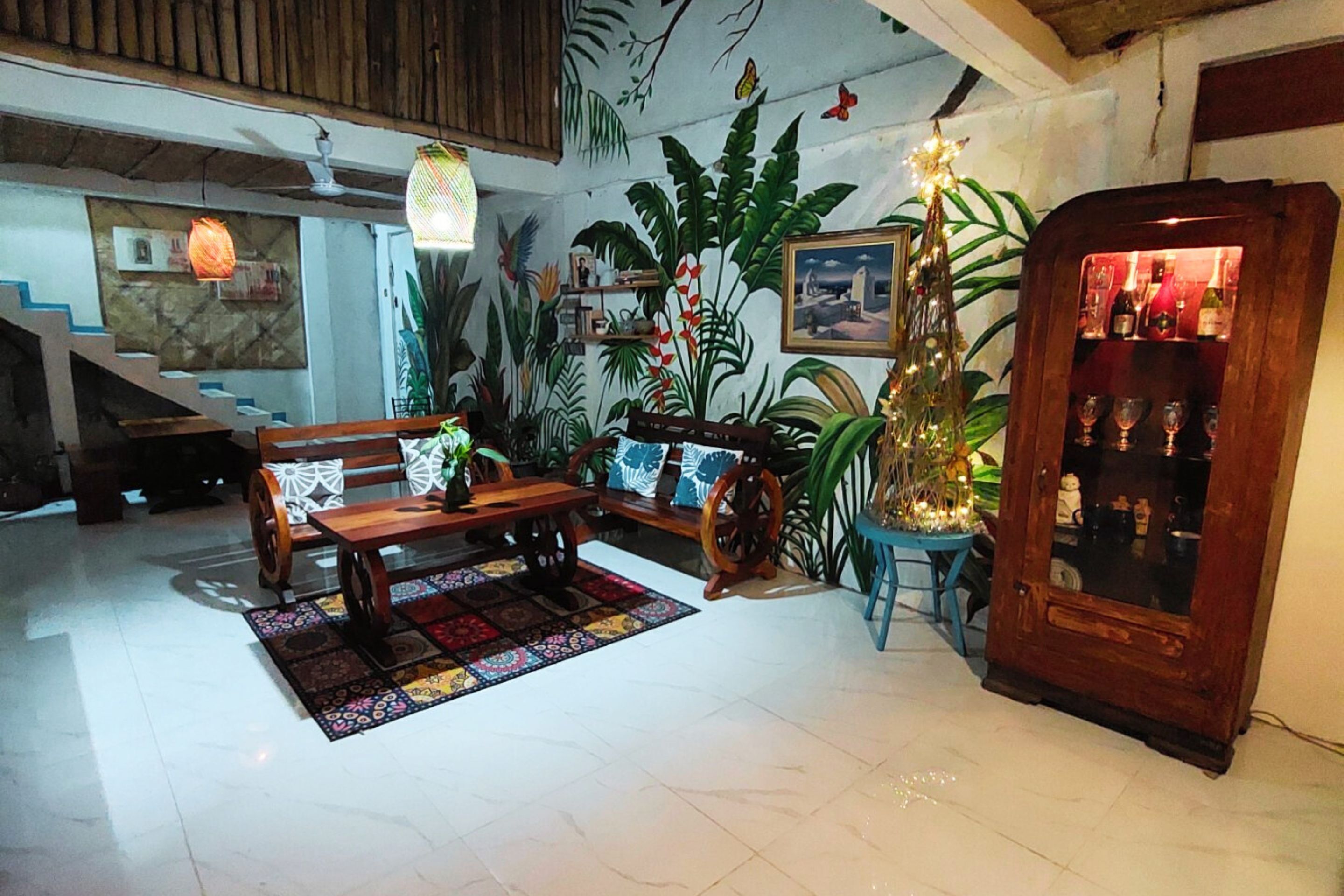 A cozy living room with a wooden bench, a small table, and a bar area with bottles.