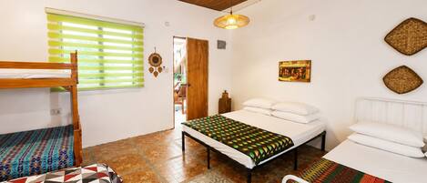 A room with a bunk bed, a single bed, a patterned rug, a hanging light fixture, and a wall-mounted picture.