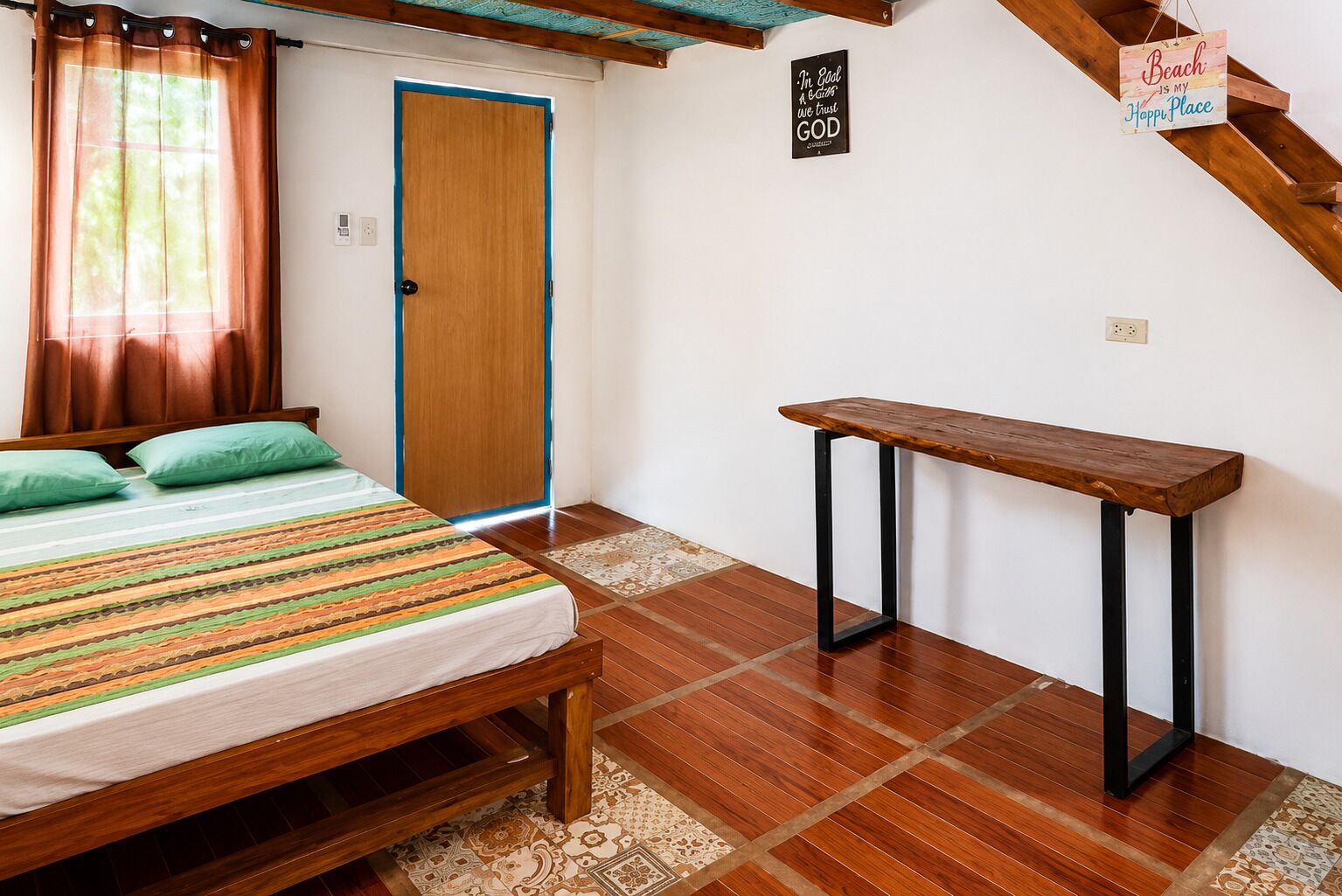 A bedroom with a bed, a bench, a door, and a wall sign.