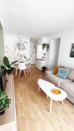 Un salon moderne comprenant un canapé, une table basse et un coin repas avec des chaises et une table.