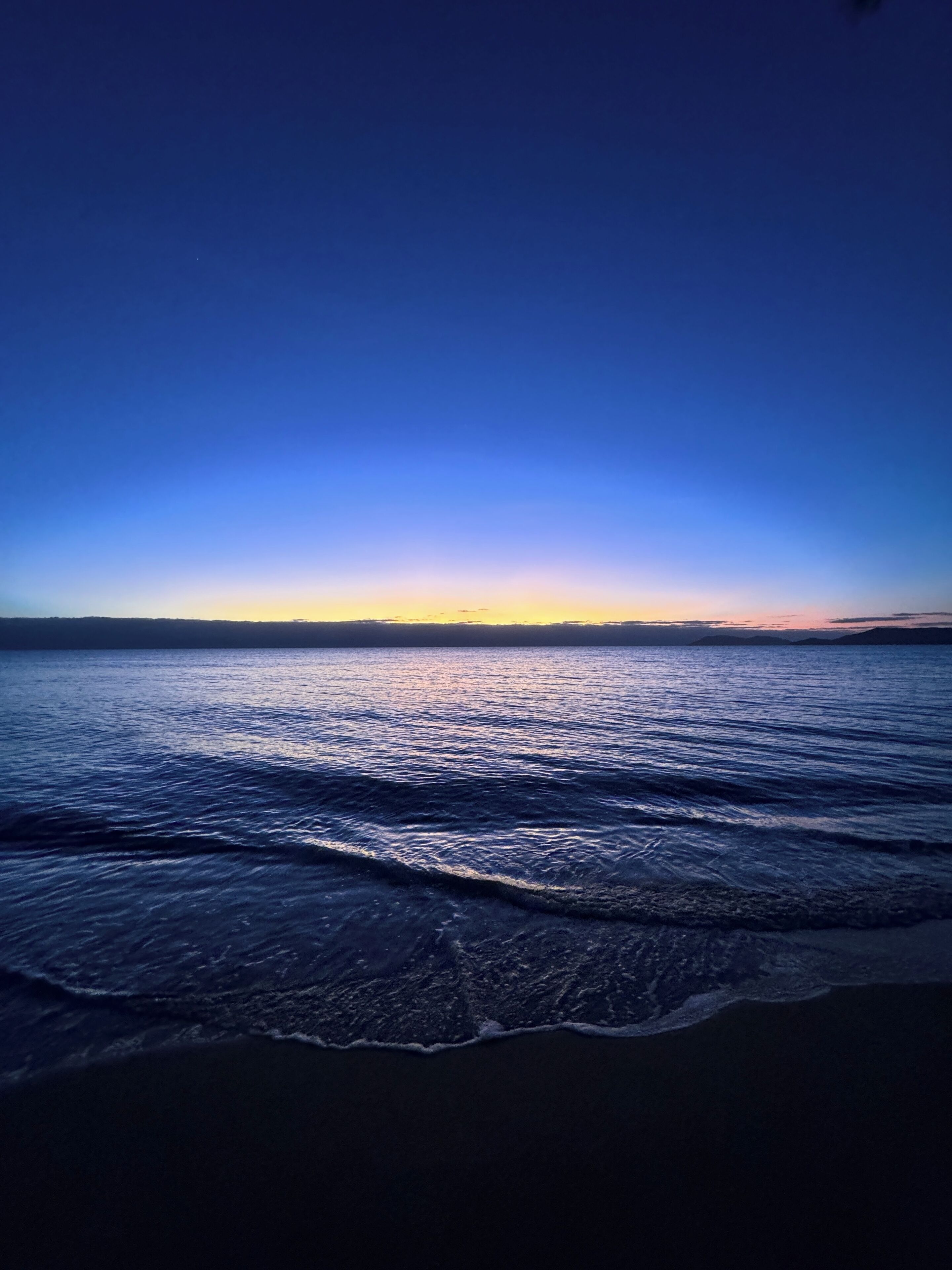 Une scène de plage avec des vagues et un ciel dégagé.