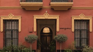 A building with a central entrance, two balconies with wrought iron railings, and a sign reading 'HONEST SEVILLE HOTEL'. - Honest Sevilla (Seville)