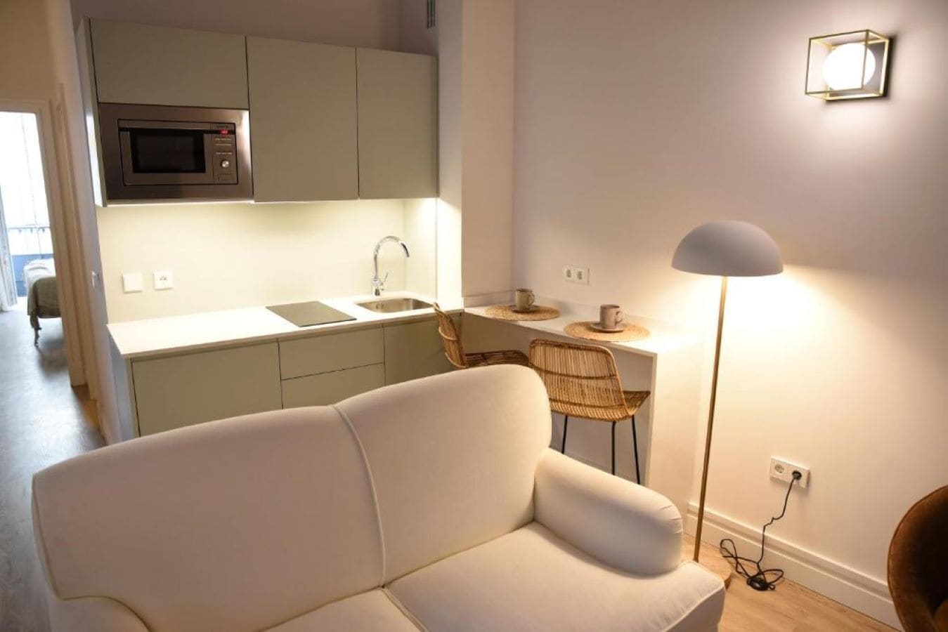 Een moderne keuken met een magnetron, spoelbak en een eethoek.