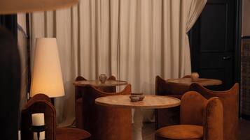 Une pièce avec une table ronde et des chaises, une lampe et un vase posé sur la table.