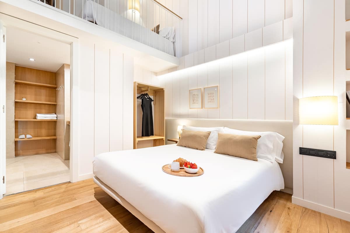 Een moderne slaapkamer met een groot bed, een inbouwkast en een balkon.