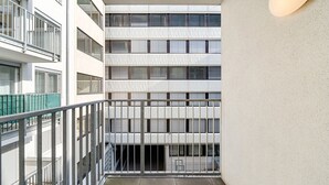 Un immeuble à plusieurs étages doté d’un balcon, de grandes fenêtres et d’une façade à motifs.