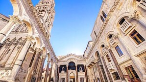 A historic building with classical architecture, featuring large columns and detailed stonework. - Sirius Luxury Rooms (Split)