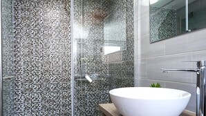 A modern bathroom with a glass-enclosed shower, a white vessel sink, and a wooden vanity. - Sirius Luxury Rooms (Split)