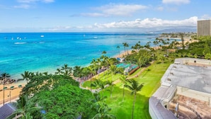 Un complejo turístico costero con playa, palmeras y vista al océano.