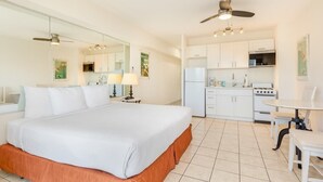 Un dormitorio con una cama grande, un escritorio y una kitchenette.