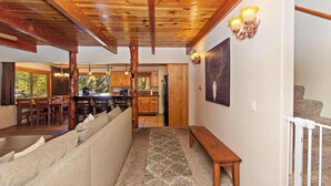 A cozy interior with a wooden ceiling, a dining area with a view, and a kitchen with wooden cabinets.