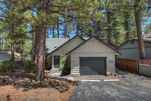 A residential property with a garage, a front door, and a driveway. - Golden Bear Pines by Destination Big Bear: Walk to Snow Summit! Fenced Yard! Pet Friendly! HOT TUB! (Big Bear Lake)