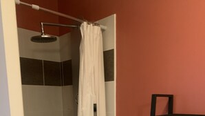 A bathroom with a white bathtub, a towel rack, and a shower area. - Central Apartment in La Roche-Posay with Pool and Terrace (La Roche-Posay)