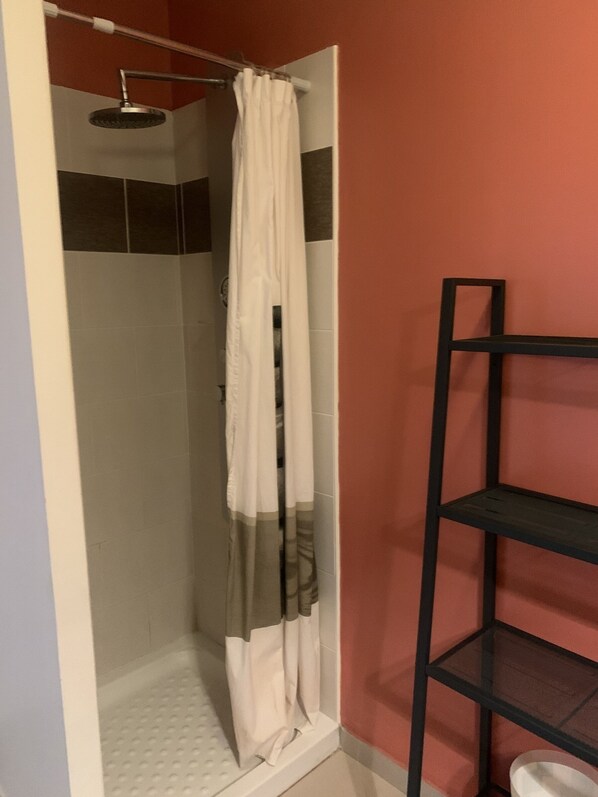 A bathroom with a white bathtub, a towel rack, and a shower area. - Central Apartment in La Roche-Posay with Pool and Terrace (La Roche-Posay)