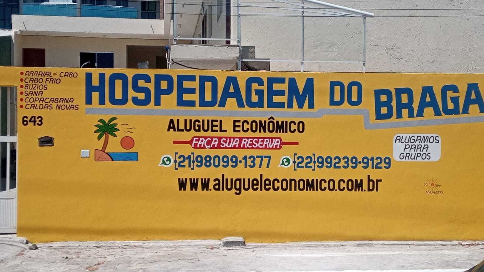 A yellow sign for 'HOSPEDAGEM DO BRAGA' with contact information and a website URL.