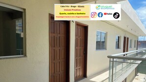 A building with a balcony, a wooden door, and a window.