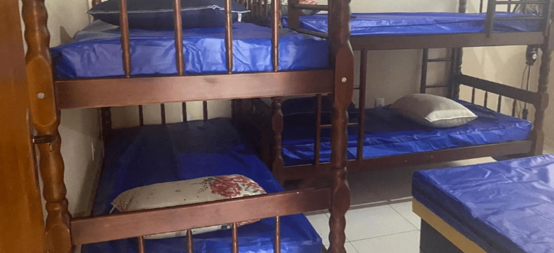 Una cama litera con ropa de cama azul y estructura de madera.