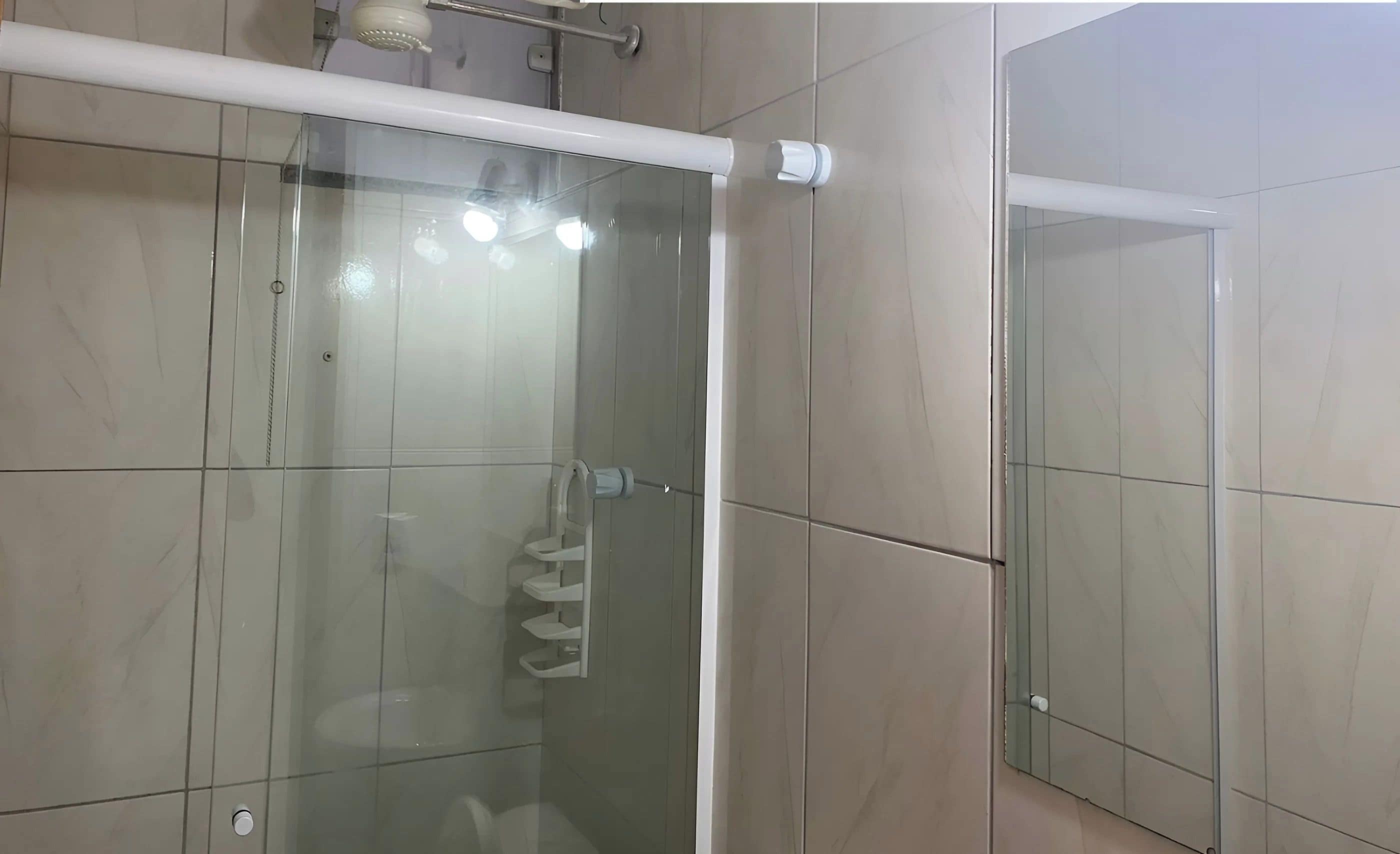 A modern bathroom with a glass shower enclosure, a white towel rack, and a visible toilet.