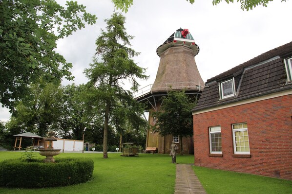 A brick building with a tower, a fountain, and a pathway.