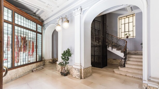 A grand hallway with a marble floor, a staircase with a wrought iron railing, and a large window with a view. - Celestina House - Prati, Rome (updated 2026) (Roma)