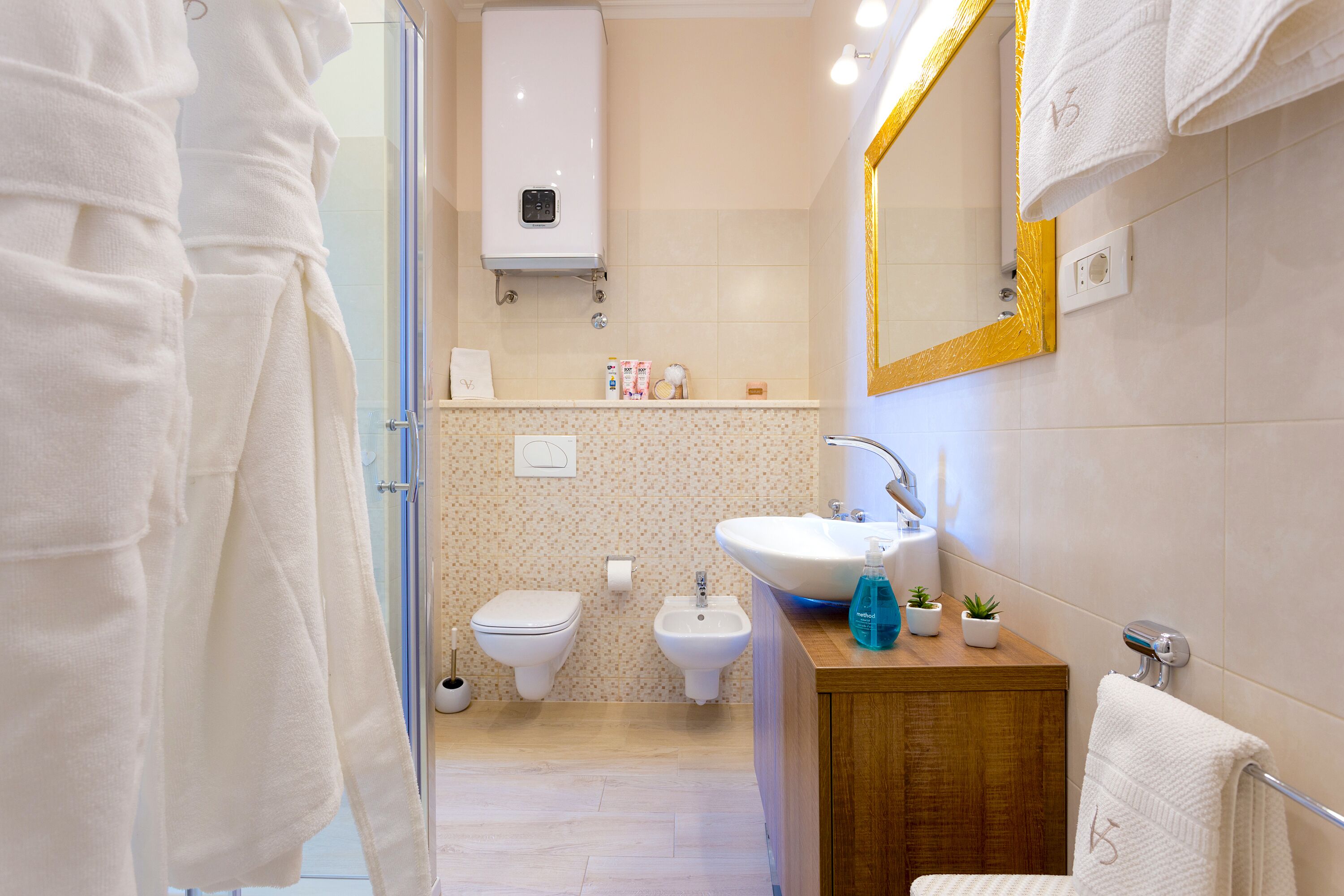A modern bathroom with a glass shower, a white sink, and a wooden vanity.