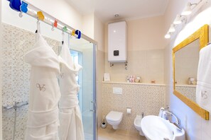 A bathroom with a glass shower enclosure, a toilet, a sink, and a mirror with a gold frame. - Victoria Luxury Rooms - Split Downtown (Split)