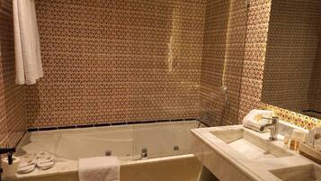 Une salle de bain avec une baignoire, un lavabo et un miroir.