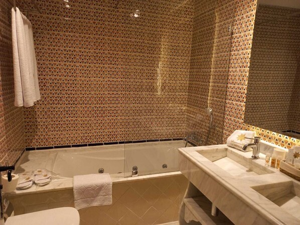 A bathroom with a bathtub, a sink, and a mirror. - La Menara Hotel & SPA (Sidi Bou Said)