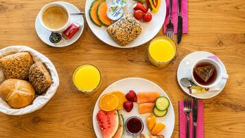 Un desayuno con diversas opciones de comida y bebidas sobre una mesa de madera.