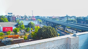 Et livligt bybillede med et tydeligt hotelskilt, flere viadukter og en blanding af erhvervs- og boligbebyggelse.