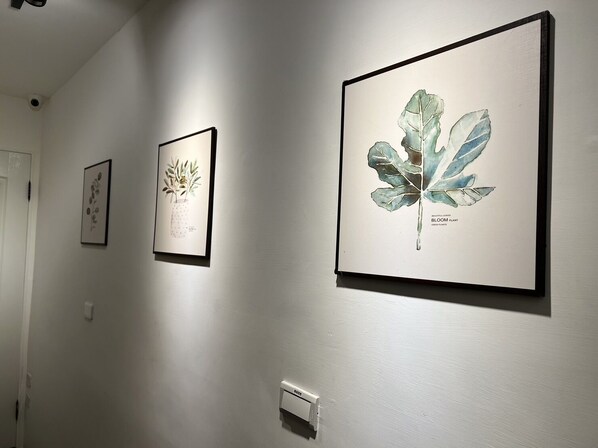 A hallway with three framed botanical illustrations on the wall.