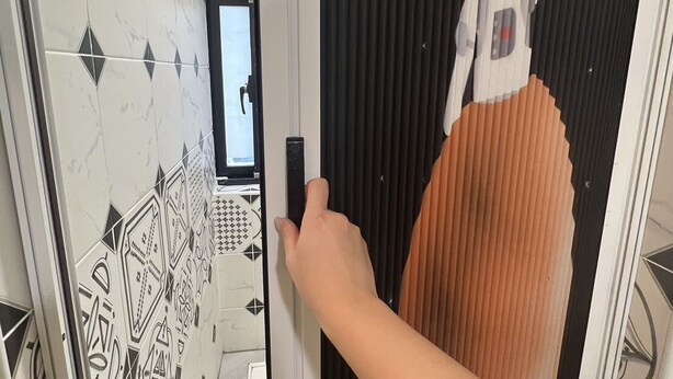 A hand opening a door with a patterned wall and a large, abstract mural. - mimi cat house (Tainan)