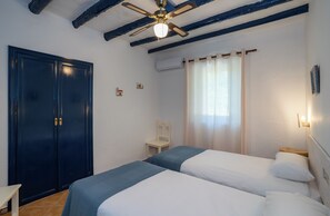A bedroom with two beds, a ceiling fan, a wardrobe, a chair, and a window with curtains. - Magnificent country house with Pool. Great views and location! (Álora)