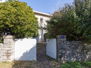 Stroll along the serene pathway to a traditional building with a stone facade and a welcoming entrance.