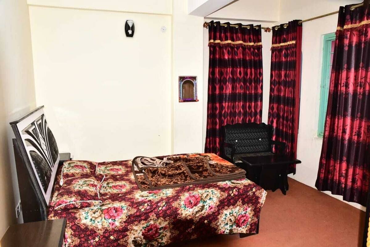 Ein Schlafzimmer mit einem Bett, einem Sessel und einem kleinen Fenster.