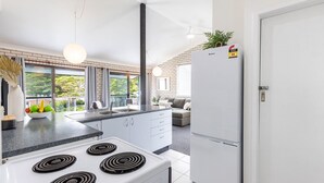 Una cocina moderna con una isla central, estufa integrada y un refrigerador.