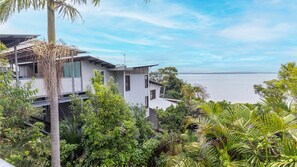 A modern coastal house with a view of the sea, surrounded by lush greenery. - Dutchies By The Sea, 2 61 Christmas Bush Ave - Spectacular views, close to the beach,  Wi-Fi (Nelson Bay)