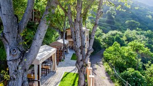 A treehouse-style restaurant with outdoor seating and a view of the surrounding forest. - Dilivita Rest House (Gosh)