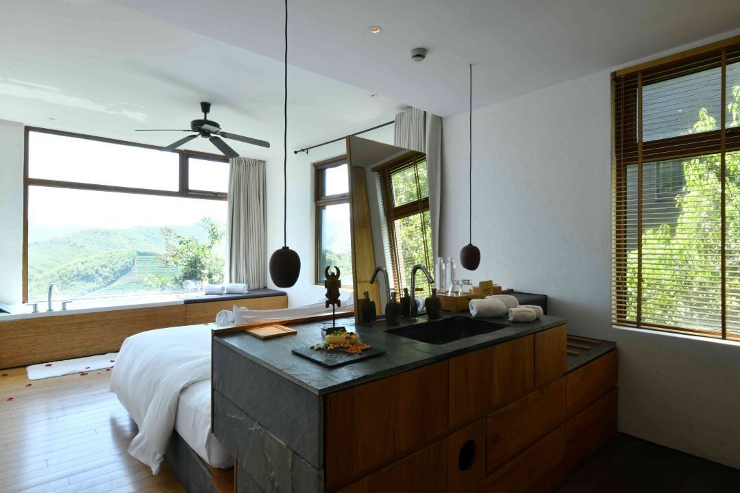 A modern bathroom with a large mirror, wooden vanity, and a sink.