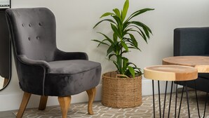 A modern living room with a grey armchair, a wooden coffee table, a potted plant, and a large abstract painting on the wall. - Waters Edge 109 (Cape Town)