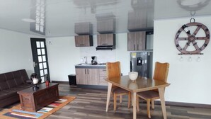 A modern living room with a glass partition, a dining table with chairs, a sofa, and a coffee table. - Captivating 4-bed Chalet Las Casitas en el Aire (San Francisco)