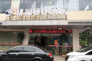 Entrada de hotel con un cartel y un número de contacto.