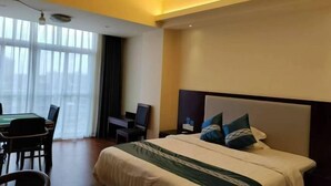 A hotel room with a bed, a desk, and a chair. - Youxian Bianjie Hotel (Dongxing)