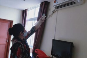 A person adjusting a curtain on a window. - Youxian Bianjie Hotel (Dongxing)