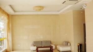 A spacious room with a large window, a sofa, a coffee table, and a lamp. - Youxian Bianjie Hotel (Dongxing)