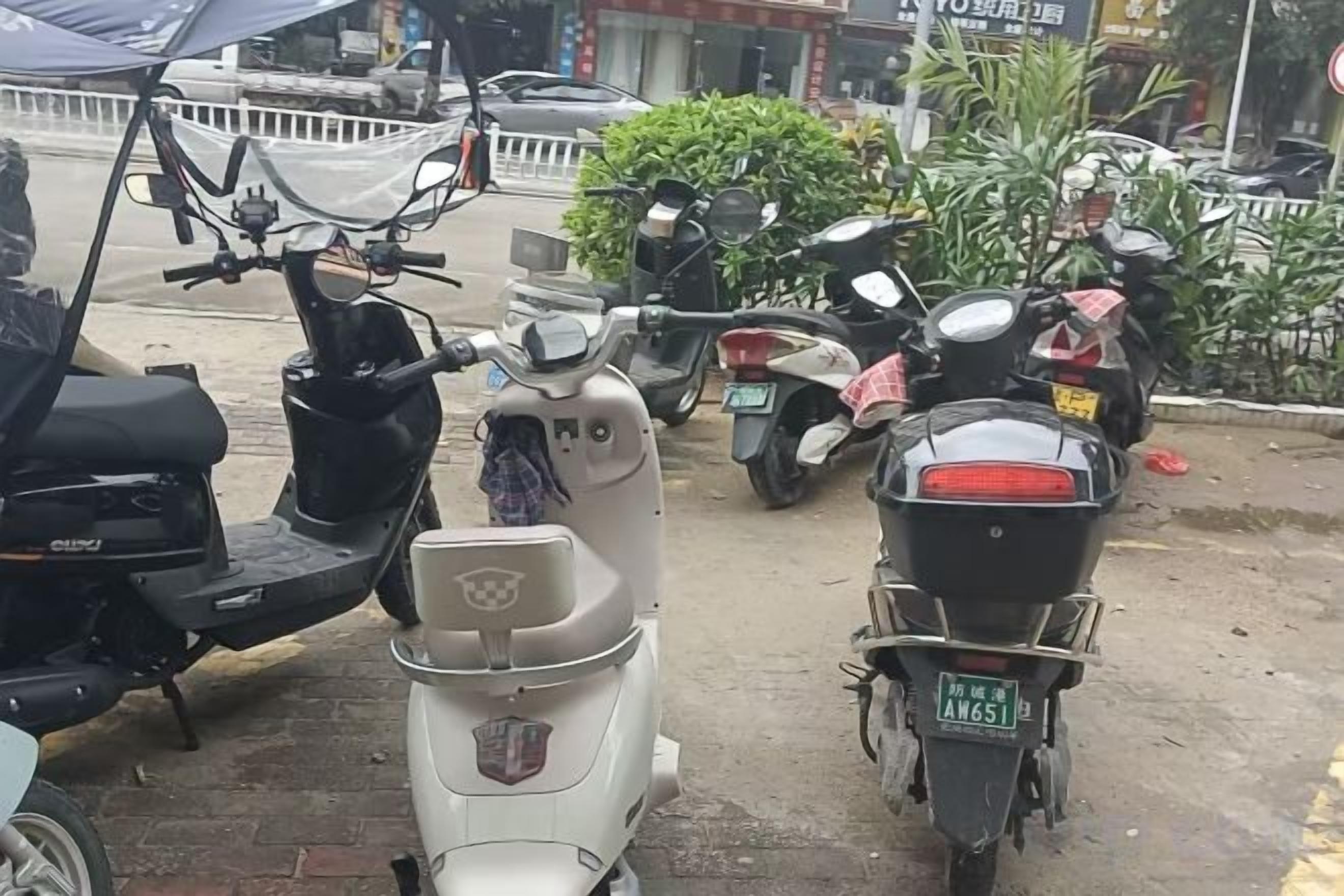 Une rangée de scooters garés dans une rue.